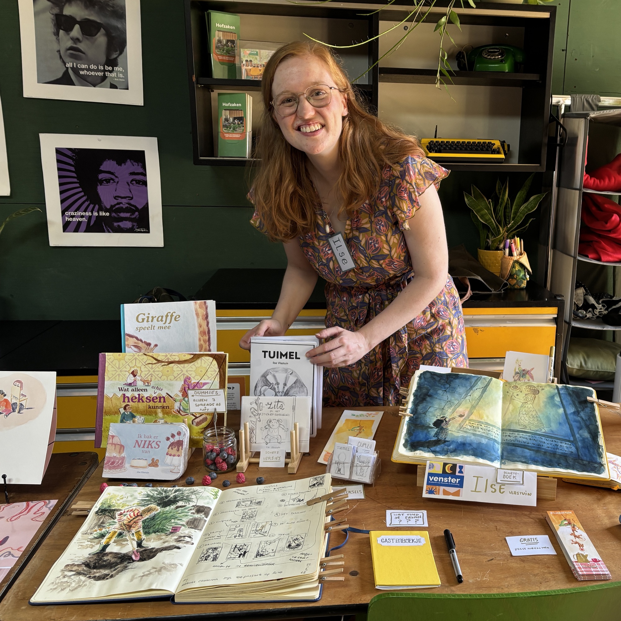 Ilse behind a table with her picturebooks, dummies and sketchbooks