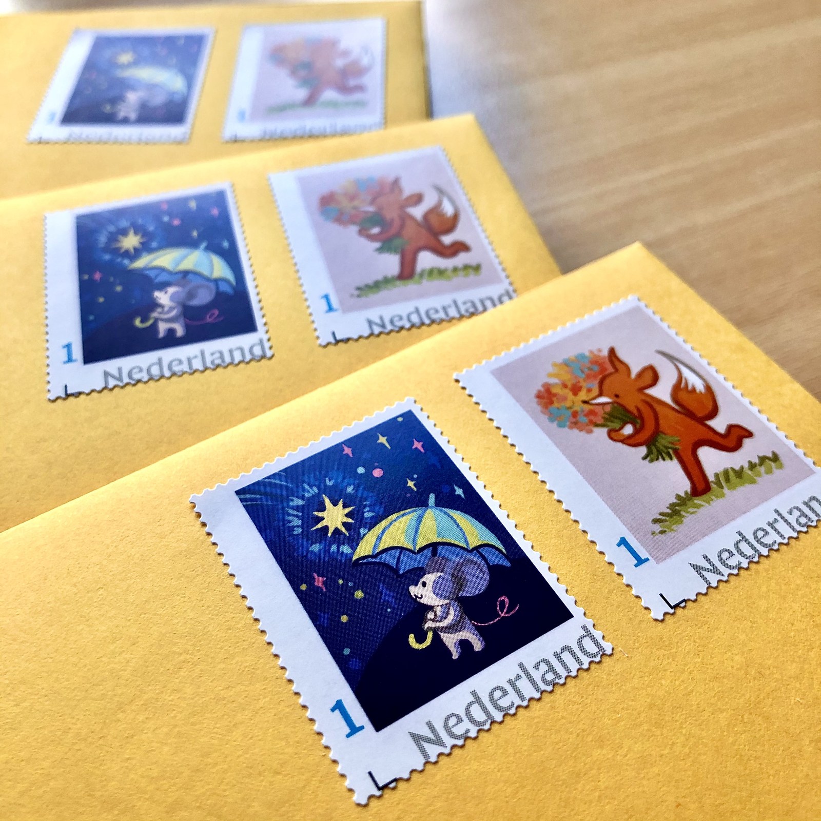 Postage stamps printed with Ilse's mouse and fox illustrations, on yellow envelopes